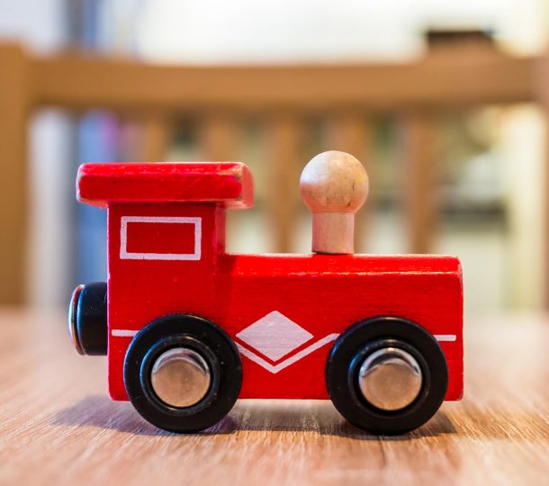 Closeup shot of a toy red wooden train on a wooden table A closeup shot of a toy red wooden train on a wooden table